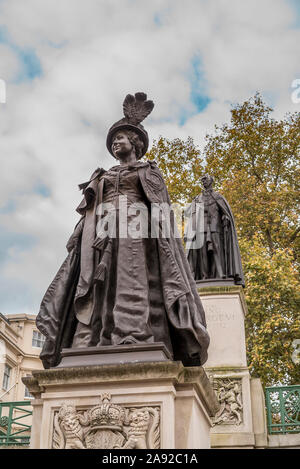 Nahaufnahme der Königin Mutter Memorial, eine Bronzestatue von Philip Jackson in der Mall, London, UK, mit König George VI Memorial im Hintergrund stehen. Stockfoto