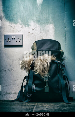 Blonde Perücke Auslaufen aus einem Rucksack. Stockfoto