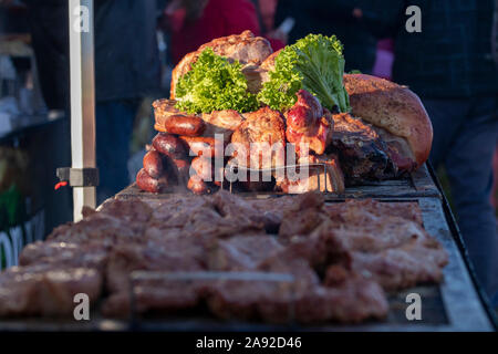 Ein Haufen gegrillte und geräucherte Fleisch- und Wurstwaren. Stücke vom Schwein werden an einer Garküche gegrillt. Nahrung fest Veranstaltung, Sommertag, unscharfen Menge backgr Stockfoto