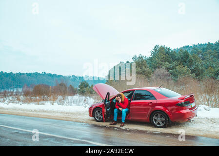 Mann im Auto sitzen um Hilfe ruft. Brechen Sie im Winter Speedway Stockfoto