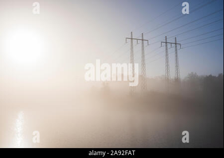 Strommasten im Nebel Stockfoto