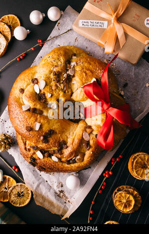 Frisch gebackene chrismtas roll Kranz auf einem hölzernen Hintergrund mit verschiedenen Weihnachten Dekoration Stockfoto