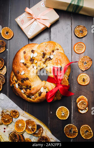 Frisch gebackene chrismtas roll Kranz auf einem hölzernen Hintergrund mit verschiedenen Weihnachten Dekoration Stockfoto