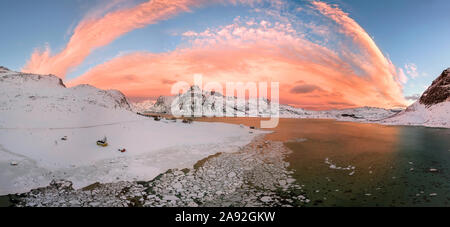 Antenne drone Panorama Foto. Schönen Sonnenuntergang über den Bergen und Meer von den Lofoten. Reine, Norwegen. Winterlandschaft mit herrlichen Farben. Stockfoto