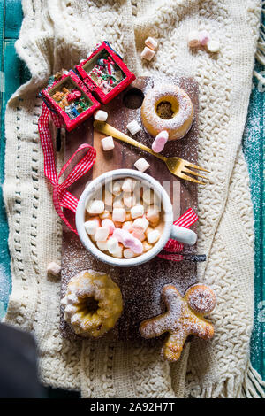 Heiße Schokolade und Marshmallows gewürzt Bundt kuchen Draufsicht mit Weihnachtsschmuck, eine rote Weihnachten Socken, kleine Kugeln und andere Dekorationen, Chr Stockfoto