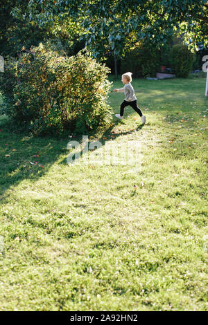 Mädchen im Garten laufen Stockfoto