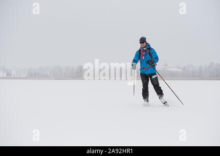 Mann, Schlittschuhlaufen auf dem zugefrorenen See Stockfoto