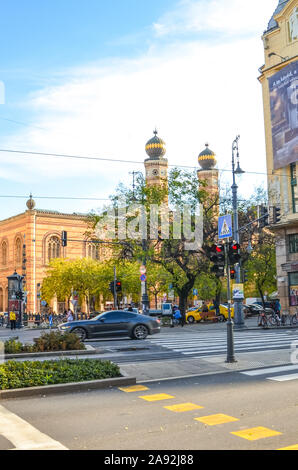 Budapest, Ungarn - Nov 6, 2019: Road im Zentrum der ungarischen Hauptstadt. Dohany Synagoge, die größte Synagoge in Europa in den Hintergrund. Zebrastreifen und Lichter in den Vordergrund. Stockfoto