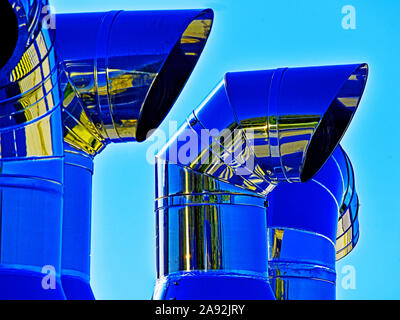 Große industrielle Chromstahl Belüftungsrohre gegen den blauen Himmel Stockfoto