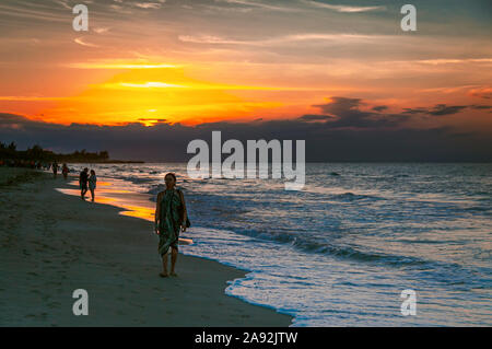 Strand von Varadero, Kuba, Jan 2013 - Frau in leichter Kleidung drapiert ihrem Spaziergang genießen bei Sonnenuntergang am Strand Stockfoto