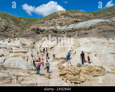 Touristen auf dem Hoodoos Trail in den kanadischen Badlands. Jeder Hoodoo ist eine Sandsteinsäule, die auf einer dicken Schieferbasis ruht, die von einem großen Stein bedeckt ist Stockfoto