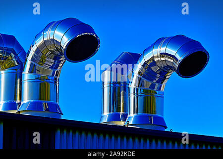 Große industrielle Chromstahl Belüftungsrohre gegen den blauen Himmel Stockfoto