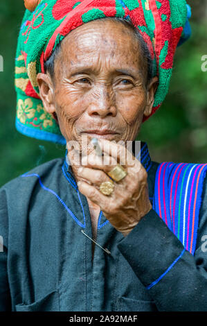 Burmesische Frau, die eine traditionelle Kopfbedeckung trägt und eine Zigarette raucht; Yawngshwe, Shan State, Myanmar Stockfoto