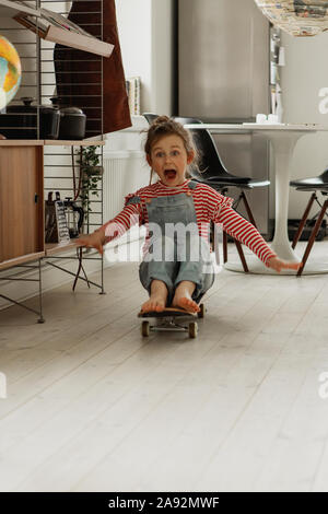 Mädchen auf Skateboard zu Hause Stockfoto