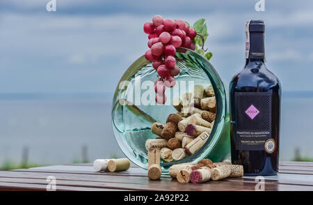 Flasche Rotwein mit Schüssel von Korken und Trauben Stockfoto