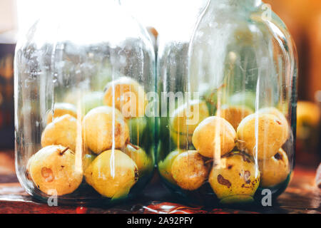 Leckere Konserven gelbe Birnen in einem dunklen Keller. Kompott. Home Winter Snack in Glas. Foto von Glas mit Birne auf Hintergrund isoliert. Dosen Birnen Stockfoto
