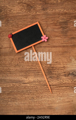 Eine kleine orange Tafel auf einem hölzernen Hintergrund mit Kopie Raum gerahmte Stockfoto