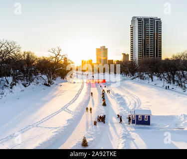 Eislaufen bei Sonnenuntergang auf dem Assiniboine River, Teil des Red River Mutual Trail bei den Forks; Winnipeg, Manitoba, Kanada Stockfoto