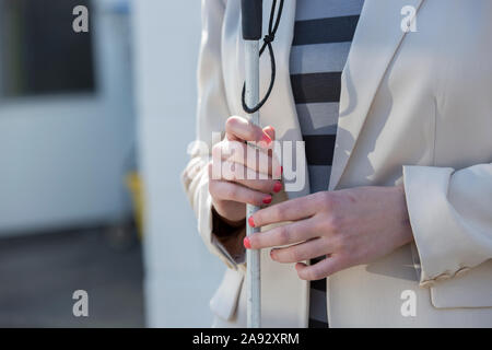 Junge blinde Frau lächelnd mit ihrem Rohrstock Stockfoto