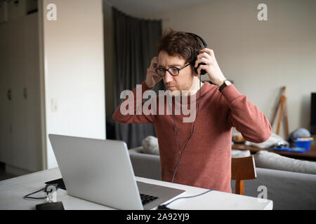 Mann mit Kopfhörer mit laptop Stockfoto