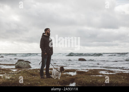 Mann mit Hund am Meer Stockfoto