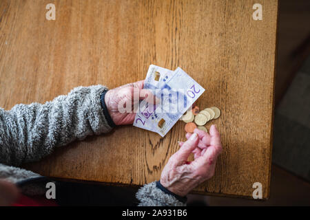 Hände, die Euro-Banknoten und -Münzen Stockfoto