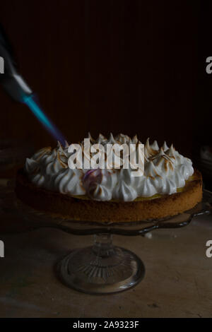 Lemon Meringue Tarte mit französischen karamellisierten oben, auf einem rustikalen Tisch, französisch Meringue karamellisierten mit Taschenlampe. Stockfoto