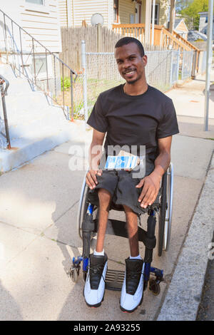 Mann in einem Rollstuhl, der Spinale Meningitis auf dem hatte City Street Stockfoto