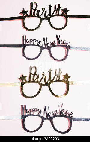 Lasst uns eine Party Theme für das neue Jahr, Thema, party Glas neue Jahre Thema, in einer Reihe, Ansicht von oben über einen rosa Hintergrund Stockfoto