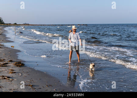 Mann mit Mops auf See Stockfoto