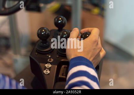 Ein Mann steuert Traktor Simulator - ein Bagger. Joystick. Stockfoto