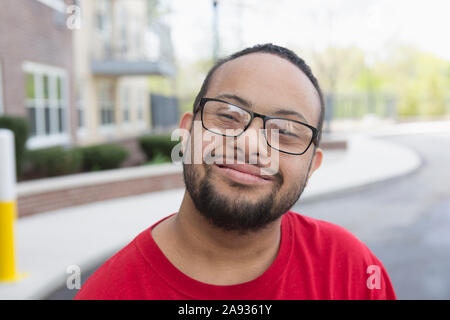 Porträt eines glücklichen afroamerikanischen Mannes mit Down-Syndrom im Freien Stockfoto