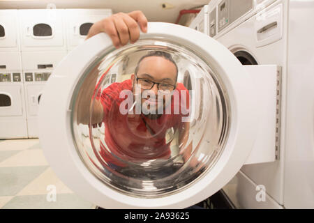 Glücklicher afroamerikanischer Mann mit Down-Syndrom beim Waschen Hauswirtschaftsraum Stockfoto