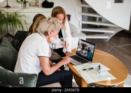 Großmutter mit Enkelinnen mit Laptop Stockfoto