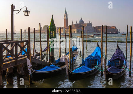 Die herrliche Aussicht auf die Gondeln günstig bis auf der Hauptinsel in Venedig, Italien - mit Blick auf den berühmten Turm von San Giorgio Kloster auf dem Stockfoto