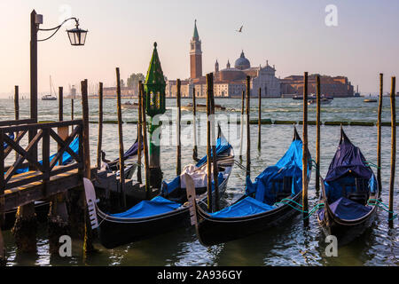 Die herrliche Aussicht auf die Gondeln günstig bis auf der Hauptinsel in Venedig, Italien - mit Blick auf den berühmten Turm von San Giorgio Kloster auf dem Stockfoto