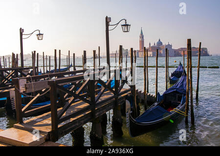 Die herrliche Aussicht auf die Gondeln günstig bis auf der Hauptinsel in Venedig, Italien - mit Blick auf den berühmten Turm von San Giorgio Kloster auf dem Stockfoto