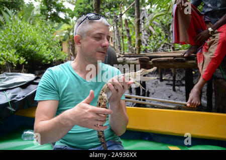 Ein Mann hält in der Hand einen kleinen Krokodil. Im Dschungel von Sri Lanka Stockfoto