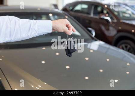 Händler, die Schlüssel zu einem neuen Auto. Moderne und repräsentative Fahrzeuge. Für den Einsatz als Hintergrund. Stockfoto