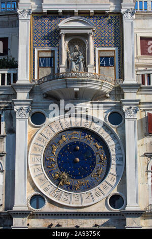 Ein Blick auf die Uhr und Jungfrau und Kind Skulptur auf St. Marks Clock Tower, an der Piazza San Marco in Venedig, Italien. Stockfoto