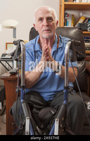 Mann mit Ataxia mit seinem Wanderer und gestikulierenden in seinem Schlafzimmer Stockfoto