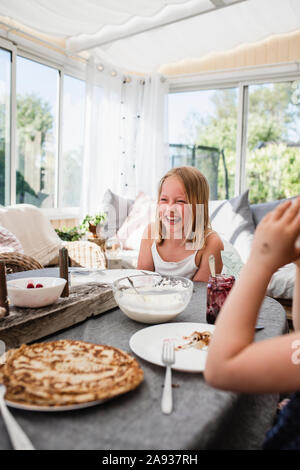 Glückliches Mädchen am Tisch Stockfoto