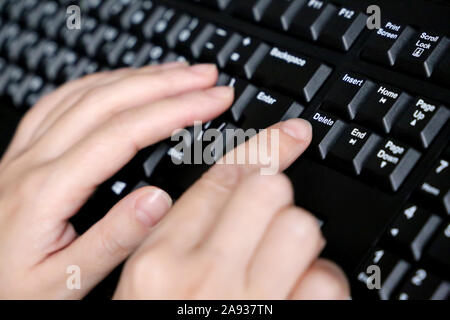 Weibliche Hände auf der Tastatur des Computers Schließen Sie herauf, selektive konzentrieren. Frau drückt die Taste Löschen, Konzept der Fehlerkorrektur Stockfoto