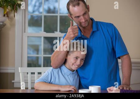 Vater sagt 'Cool' in American Sign Language mit Sohn an Zu Hause Stockfoto