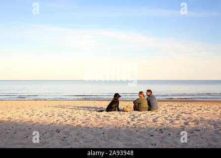 Paar mit Hund Erholung am Strand Stockfoto