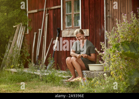 Frau vor Haus Stockfoto