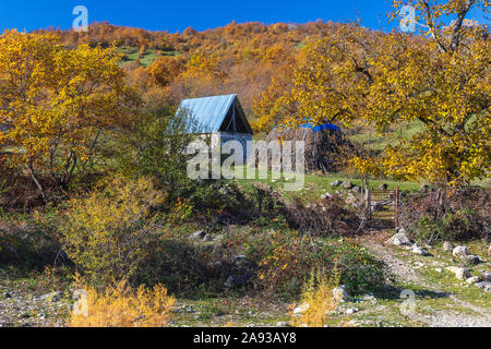 Kleines Haus aus Stein und haystack Herbst Wald in den Bergen Stockfoto