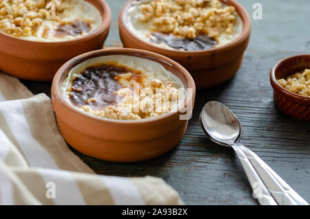 Türkische Milchreis sutlac, türkisches Dessert auf Holztisch. Stockfoto