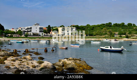 Uvala Stoja Bucht mit kleinen alte Pier, Boote und modernen Gehäuse an der Rückseite des Shoreline, Stadtrand von Pula, Kroatien Stockfoto