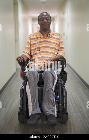 Mann mit Guillain-Barre-Syndrom im Flur seiner Wohnung Elektrisch Stockfoto